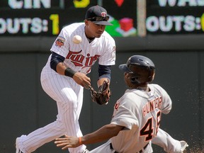 Minnesota shortstop Eduardo Escobar, left, mishandles the throw as Detroit's Torii Hunter, right, slides in safely on a fielder's choice during the third inning Sunday in Minneapolis. (AP Photo/Tom Olmscheid)