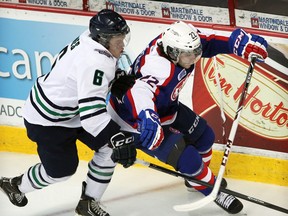 Plymouth's Mitch Jones, left, checks Windsor's Sam Povorozniouk during OHL action at the WFCU Centre on December 31, 2013.  (NICK BRANCACCIO/The Windsor Star)