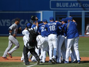 Nolan Reimold Toronto Blue Jays is congratulated by teammates after hitting the game-winning RBI double in the tenth inning against the Detroit Tigers on August 9, 2014 at Rogers Centre in Toronto, Ontario, Canada. (Tom Szczerbowski/Getty Images)