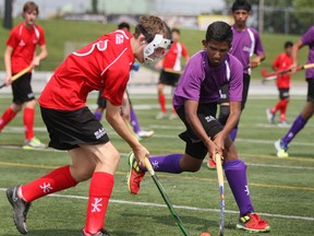 Eastern Ontario's Alex Darling, left, battles Brampton's Duane D'Souza for the ball during field hockey competition at Alumni Field for the Ontario Summer Games Friday. (DAX MELMER/The Windsor Star)