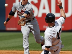 Detroit shortstop Andrew Romine, left, reacts as he fields Brett Gardner's seventh-inning ground ball single that bounced in the infield as New York's Brendan Ryan slides into second at Yankee Stadium. (AP Photo/Kathy Willens)