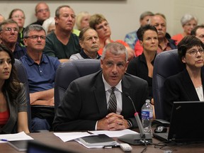 James Lanoue, centre, a partner with Deloitte, is flanked by his colleague, Aneesa Ruffudeen, left, senior manager at Deloitte, and Ginette Brindle, regional director, Ontario Ministry of Municipal Affairs and Housing, as they give their financial review findings before Amherstburg Town Council,  Monday, August 11, 2014.