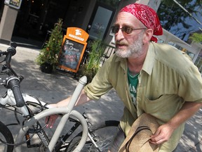 Larry Leeder, 45,  is pictured next to a locked up bike in downtown Windsor, August 25, 2014.  Leeder has had four bikes stolen in 2 years.  (DAX MELMER/The Windsor Star)