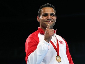 Gold medal winner Samir El-Mais from Canada poses during the medals ceremony after defeating New Zealand's David Light in the men's heavyweight 91kg boxing final during the 2014 Commonwealth Games in Glasgow, Scotland, Saturday, Aug. 2, 2014.  (AP Photo/Peter Morrison)