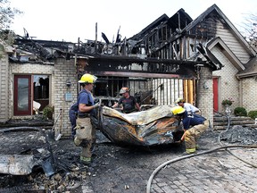 LaSalle firefighters clean up the scene of a fire on Crystal Harbour Dr, in LaSalle, ON. on Thursday, August 14, 2014. A total of three condo units were heavily damaged by the early morning fire. (DAN JANISSE/The Windsor Star)