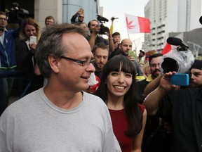 Marijuana activist Marc Emery (centre) and his wife Jodie (right) are cheered moments after Emery's exit from the Windsor-Detroit tunnel plaza on Aug. 12, 2014. (Dax Melmer / The Windsor Star)