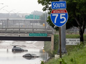 Cars are stranded along a flooded stretch of Interstate 75 in Hazel Park, Mich., Tuesday, Aug. 12, 2014. Fearing more motorists could become stranded a day after a storm dumped more than 6 inches of rain in some places in and around Detroit, the state warned commuters against driving in affected areas Tuesday morning. (AP Photo/Carlos Osorio)