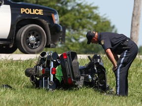 An OPP officer works at the scene of a fatal motorcycle accident at the intersection of County Road 46 and Rochester Townline Road, Wednesday, August 13, 2014. A 52 year old man riding a motorcycle was struck by a pick-up truck and died at the scene. (DAX MELMER/The Windsor Star)