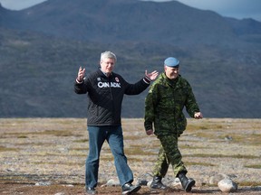 Canadian Prime Minister Stephen Harper (left) speaks with Commander Joint Task Force North Brig.Gen. Greg Loos as they make there way to speak to troops Tuesday August 26, 2014 on Baffin Island near York Sound, Nunavut. THE CANADIAN PRESS/Adrian Wyld