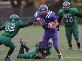 WINDSOR, ONTARIO - NOVEMBER 4, 2013 - Assumptions Desmond Vero is tackled by Lajeuness defendersduring the senior boys high school football game against at Windsor Stadium on November 4, 2013 in Windsor, Ontario. (JASON KRYK/The Windsor Star)