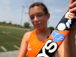Emelia Payne, 16, holds her field hockey stick with the initials J.P. on a heart taped to the side while competing for the Central East field hockey team in the Ontario Summer Games at Alumni Field, Saturday, August 9, 2014.  Jaime Palm, a former teammate, died two weeks ago after a soccer net collapsed on her.  (DAX MELMER/The Windsor Star)