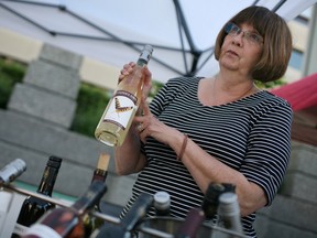 WINDSOR, ONT.: MAY 30, 2014 -- Katy O'Brien, from Cooper's Hawk Winery, sells bottles of wine on the opening day of the Downtown Farmer's Market at Charles Clark Square in downtown Windsor, Saturday, May 31, 2014.  This is the first year that farmer's markets are allowed to sell local wines.  (DAX MELMER/The Windsor Star)