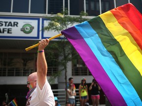Darren Farkas raises the gay pride flag during the Windsor Essex Pride Fest parade in downtown Windsor, Sunday, August 10, 2014.  (DAX MELMER/The Windsor Star)