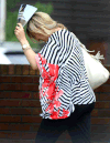 A woman in downtown Windsor holds up a magazine against the rain on Aug. 11, 2014. (Dan Janisse / The Windsor Star)