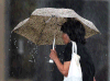 A woman in downtown Windsor attempts to shield herself from heavy rain with an umbrella on Aug. 11, 2014. (Dan Janisse / The Windsor Star)