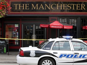 Windsor police officers investigate after a man fell from the roof of The Manchester in downtown Windsor, late Monday morning, August 25, 2014.  (DAX MELMER/The Windsor Star)