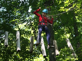 A group of 85 local youngsters have been spending the last few days at the OPP Cop Camp at the GessTwood Retreat & Camp Centre in Essex, ON. The children all participated in VIP (Values Influences and Peers) last school year. Several local O.P.P. staff members have been volunteering to help run the camp. The rope challenges are a highlight of the experience. Derin Yilmaz carefully makes his way across rope course.    (DAN JANISSE/The Windsor Star)