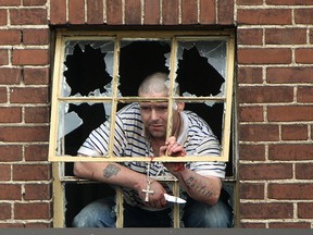 A man barricaded in an apartment at 1616 Ouellette Ave., brandishes a knife while speaking to the Windsor police through the apartment window, Sunday, August 31, 2014.  The standoff ended peacefully and the man was taken into custody.  No reported injuries.  (DAX MELMER/The Windsor Star)