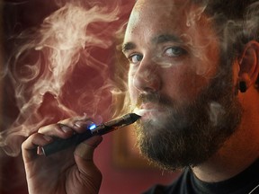 Geoff Zanetti smokes an e-cigarette on Friday, August 15, 2014, at Villians Beastro, the bar he owns in downtown Windsor, ON. He is opposed to the idea of e-cigarettes being banned like tobacco products. (DAN JANISSE/The Windsor Star)