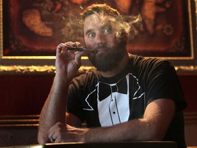 Geoff Zanetti smokes an e-cigarette on Friday, August 15, 2014, at Villians Beastro, the bar he owns in downtown Windsor, ON. He is opposed to the idea of e-cigarettes being banned like tobacco products. (DAN JANISSE/The Windsor Star)