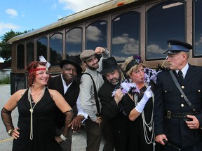 Actors in the Rumrunners Tour, from left, Misty Habib, Jim Walls, Kyle J. Pitry, Rob Tymec, Michelle Mainwaring, Paul Cousins, and Mark Baker, owner of the tour, are pictured next to the tour bus at Rosa's Italian Restaurant in LaSalle.  (DAX MELMER / The Windsor Star)