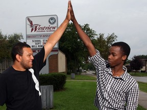 Michael Nicholls, 19, left, a former student with Century High School, gives former Forster High School student Jibril Ahmed, 18, a high five at the newly opened Westview Freedom Academy on California Avenue Tuesday September 2, 2014.  (NICK BRANCACCIO/The Windsor Star)
