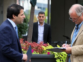 Ward 1 candidate Fred Francis, left,  holds a press conference dealing Francis' plan to help those stricken with home and yard flooding Monday September 15, 2014. Windsor Star reporter Doug Schmidt, right, takes notes while current Mayor Eddie Francis listens to his brother's delivery. (NICK BRANCACCIO/The Windsor Star)