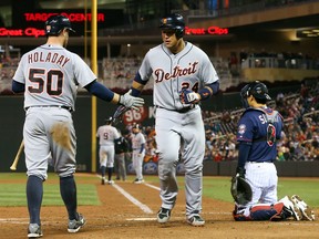 Detroit's Bryan Holaday, left, congratulates Miguel Cabrera as he scores on a bases-loaded walk by Minnesota relief pitcher A.J. Achter in the fifth  inning Monday in Minneapolis. (AP Photo/Jim Mone)
