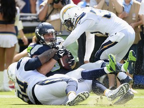 LaSalle's Luke Willson, centre, is tackled by defensive end Corey Liuget, left, and outside linebacker Jeremiah Attaochu of the San Diego Chargers at Qualcomm Stadium in San Diego. (Harry How/Getty Images)
