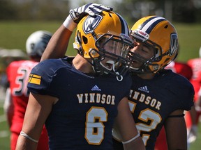 Windsor's Jake Nicoletti, left, celebrates with Frank Renaud, right, after Nicoletti made a tackle against the Carleton Ravens. (DAX MELMER/The Windsor Star)