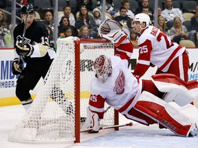 Pittsburgh's Nick Spaling, left, watches the puck land on the back of the net as Detroit goalie Jimmy Howard, centre, dives across the goal crease with Cory Emmerton  behind him during the pre-season game in Pittsburgh. (AP Photo/Gene J. Puskar)