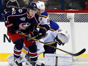 Tecumseh's Kerby Rychel, left, is checked by Maxim Lapierre of the Blues in a pre-season game in Columbus. (AP Photo/Paul Vernon)