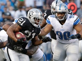 Oakland running back Maurice Jones-Drew, left, runs against Detroit Lions defensive tackle Ndamukong Suh during a pre-season game in Oakland. (AP Photo/Marcio Jose Sanchez)