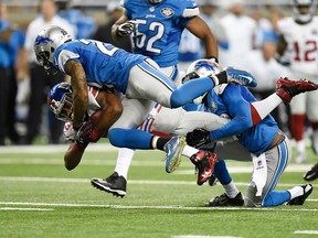 Rashad Jennings #23 of the New York Giants is tackled by Glover Quin #27 and Isa Abdul-Quddus #42 of the Detroit Lions during the second quarter at Ford Field on September 8, 2014 in Detroit, Michigan. (Photo by Joe Sargent/Getty Images)