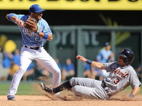 Kansas City's Omar Infante turns a double play over Detroit's Ian Kinsler in the fifth inning at Kauffman Stadium on Sept. 21, 2014 in Kansas City, Missouri.  (Photo by Ed Zurga/Getty Images)
