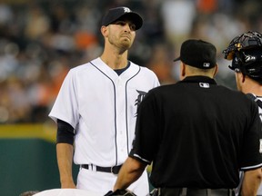Tigers pitcher Rick Porcello, top left, is checked by Tigers head athletic trainer Kevin Rand, bottom, after taking a line drive off his ankle against the San Francisco Giants in the third inning Friday in Detroit. (AP Photo/Jose Juarez)