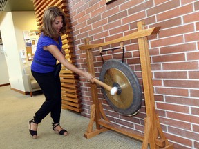 Michelle Prince bangs a gong to mark her last chemo treatment at the Windsor Regional Cancer Centre in Windsor on Thursday, September 4, 2014.                   (TYLER BROWNBRIDGE/The Windsor Star)