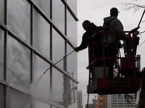 WINDSOR, ONTARIO- SEPTEMBER 11, 2014 - Workers with Tecumseh Window Cleaning spray the windows at the Chrysler Canada headquarters at One Riverside Drive west in Windsor, Ontario on September 11, 2014. (JASON KRYK/The Windsor Star)