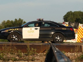Police and firefighters are shown at the scene of a fatal train accident on Tuesday, Sept. 2, 2014, in Tecumseh, ON. A 54-year-old man was killed after being hit by a VIA train on the tracks on Manning Road just south of Tecumseh Road. (DAN JANISSE/The Windsor Star)