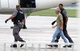 A man is escorted off a plane after the flight was greeted by police officers on the ground in Windsor on Tuesday, September 2, 2014. The flight crew requested police after a pair of passengers became unruly on the flight from Calgary.               (Tyler Brownbridge/The Windsor Star)