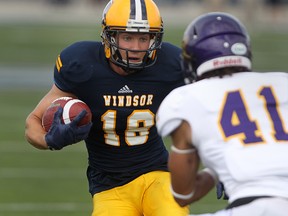 Windsor wide receiver Evan Pszczonak carries the ball against Laurier's Isaiah Guzylak during OUA Football action at Alumni Field, Saturday, Sept. 6, 2014. Windsor defeated Laurier 39-34.  (DAX MELMER/The Windsor Star)