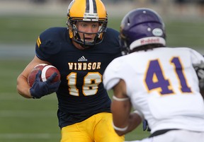 Windsor wide receiver Evan Pszczonak carries the ball against Laurier's Isaiah Guzylak during OUA Football action at Alumni Field, Saturday, Sept. 6, 2014. Windsor defeated Laurier 39-34.  (DAX MELMER/The Windsor Star)