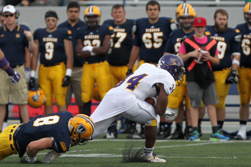 Windsor's Josh Burn-Hurley, left, tries to take down Laurier running back, Dillon Campbell as the Windsor Lancers host the Laurier Gold Hawks in OUA Football action at Alumni Field, Saturday, Sept. 6, 2014.     Windsor defeated Laurier 39-34.  (DAX MELMER/The Windsor Star)