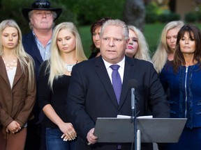 Doug Ford speaks to the media outside his mother's Etobicoke home as family members stand behind him on Friday September 12, 2014. Toronto Mayor Rob Ford's brother says he is running for mayor in order to carry on the work the two of them started in the past four years.THE CANADIAN PRESS/Chris Young