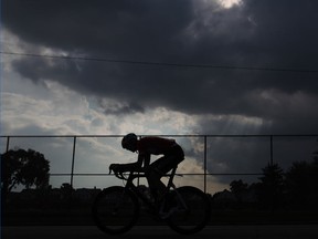 A cyclist is silhouetted under a cell of dark clouds as he competes in the 56th annual Tour di via Italia's pro, elite 1 and 2 race, Sunday, August 31, 2014.  (DAX MELMER/The Windsor Star)