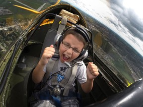Shane Jensen, 8, can't contain his excitement as he takes in a flight in a vintage de Havilland Canada DHC-1 Chipmunk for the Top Gun: Kids with Cancer Take Flight at the Windsor International Airport, Saturday, Sept. 6, 2014.  Jensen was diagnosed with a form of cancer in August of 2012 but has since been in remission.  (DAX MELMER/The Windsor Star)