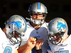 Detroit Lions quarterbacks Matthew Stafford, from left, Dan Orlovsky and Kellen Moore huddle before taking the field for warm ups before a pre-season game against the Buffalo Bills, Thursday, Aug. 28, 2014, in Orchard Park, N.Y. (AP Photo/Bill Wippert)