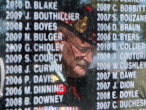 Lt. Colonel, Morris Brause, is reflected in the Afghanistan and Peacekeepers Memorial during its dedication at Reaume Park, Sunday, Sept. 7, 2014.  Listed are the names of 158 Canadians that died in Afghanistan.  (DAX MELMER/The Windsor Star)