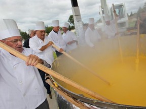 Volunteers help stir a large pot full of polenta during the Fogolar Furlan's Guiness World Record attempt for the largest polenta during Polentafest, Satuday, September 13, 2014.  The festival reclaimed the world record with a weight of 9,850 lbs.   (DAX MELMER/The Windsor Star)