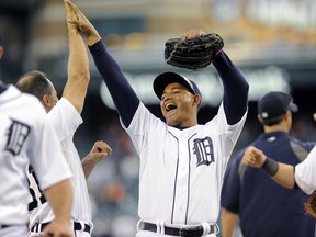 Detroit Tigers center fielder Ezequiel Carrera high fives first base coach Omar Vizquel following the Tigers' 9-5 win over the Kansas City Royals at Comerica Park in Detroit, Monday, Sept. 8, 2014. (AP Photo/Lon Horwedel)